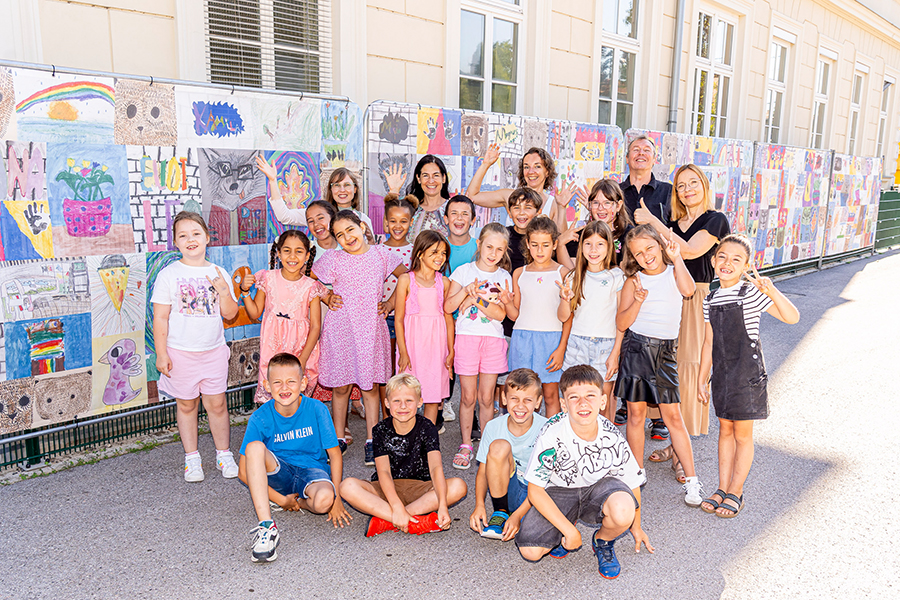 Bauzaun als Leinwand: Die Kids einer zweiten Klasse der VS Algersdorf vor ihren Kunstwerken © Stadt Graz/Fischer Bauzaun als Leinwand: Die Kids einer zweiten Klasse der VS Algersdorf vor ihren Kunstwerken